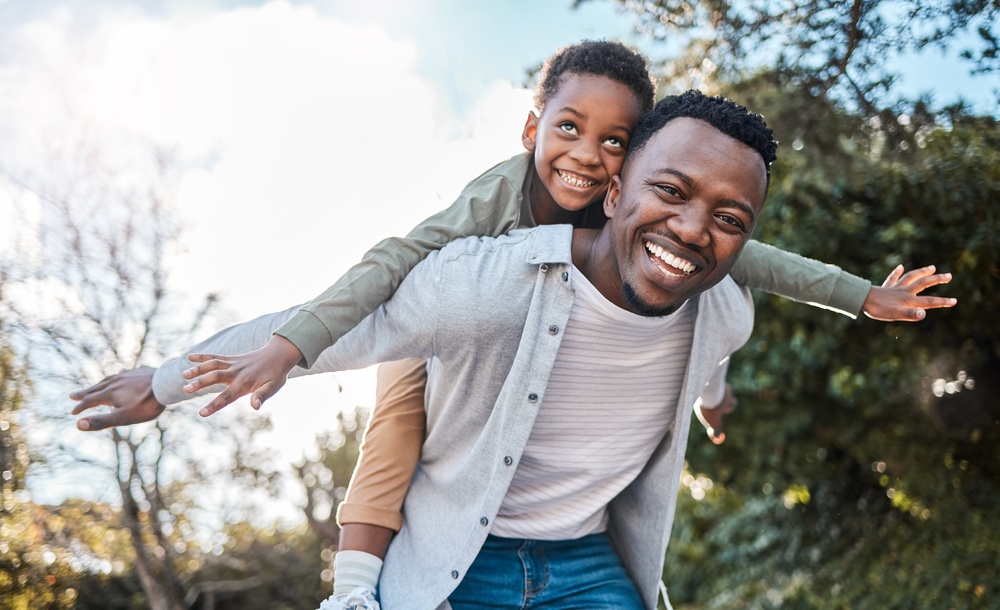Smiling father giving his son a piggyback ride outdoors