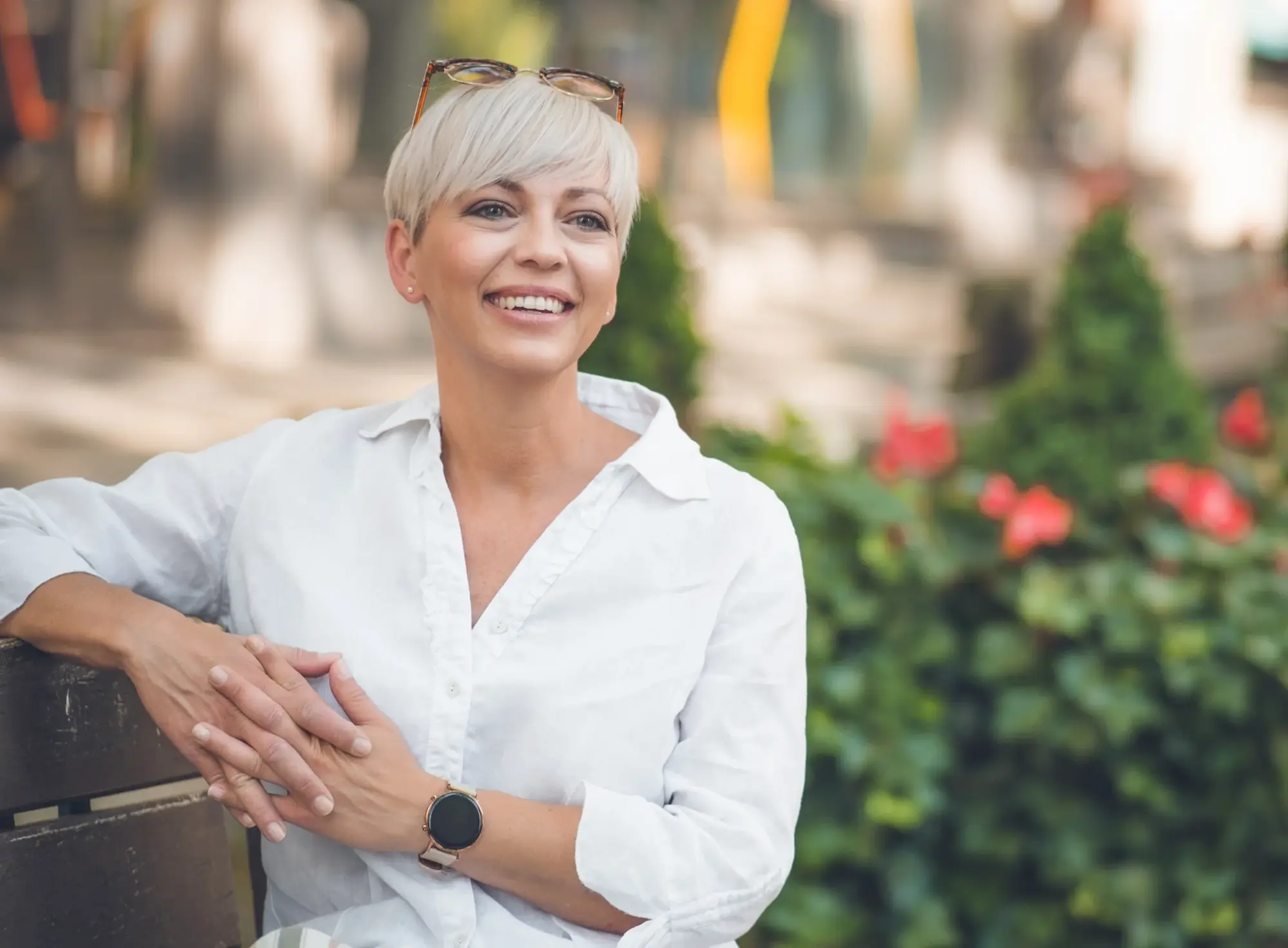 Woman with short silver hair smiling outdoors