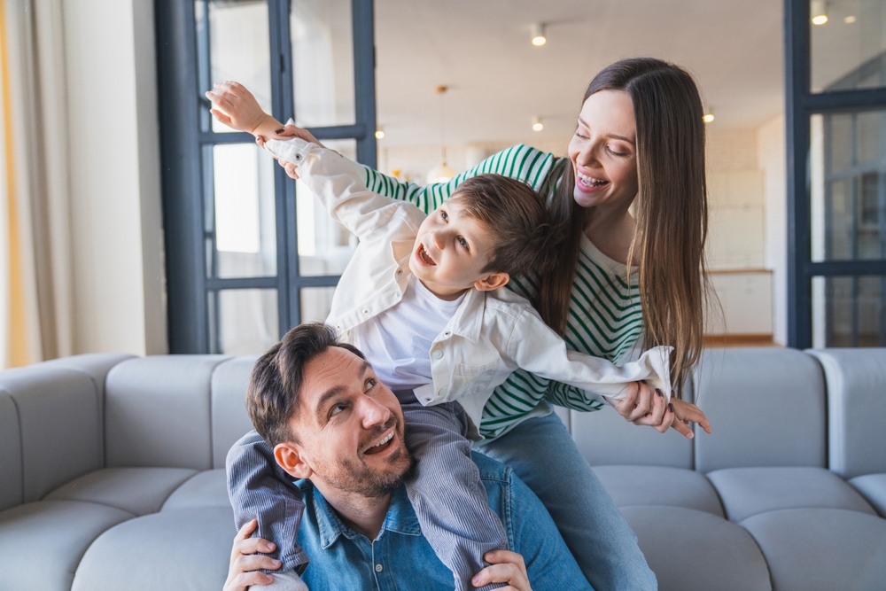 Smiling parents playing with their son at home